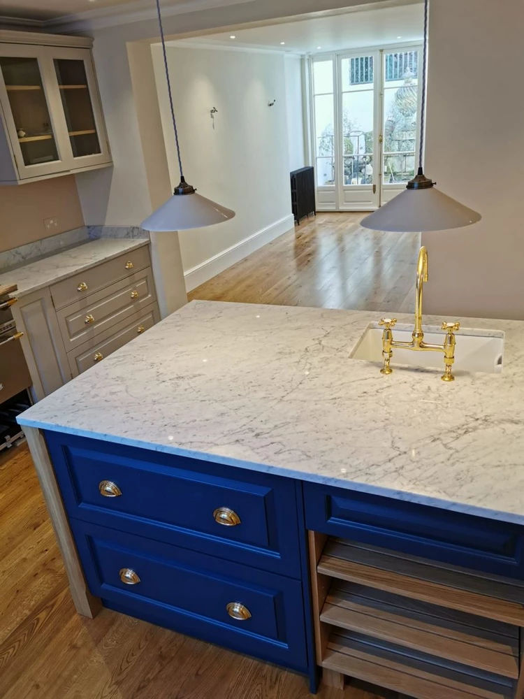 kitchen island with blue cabinets and marble top
